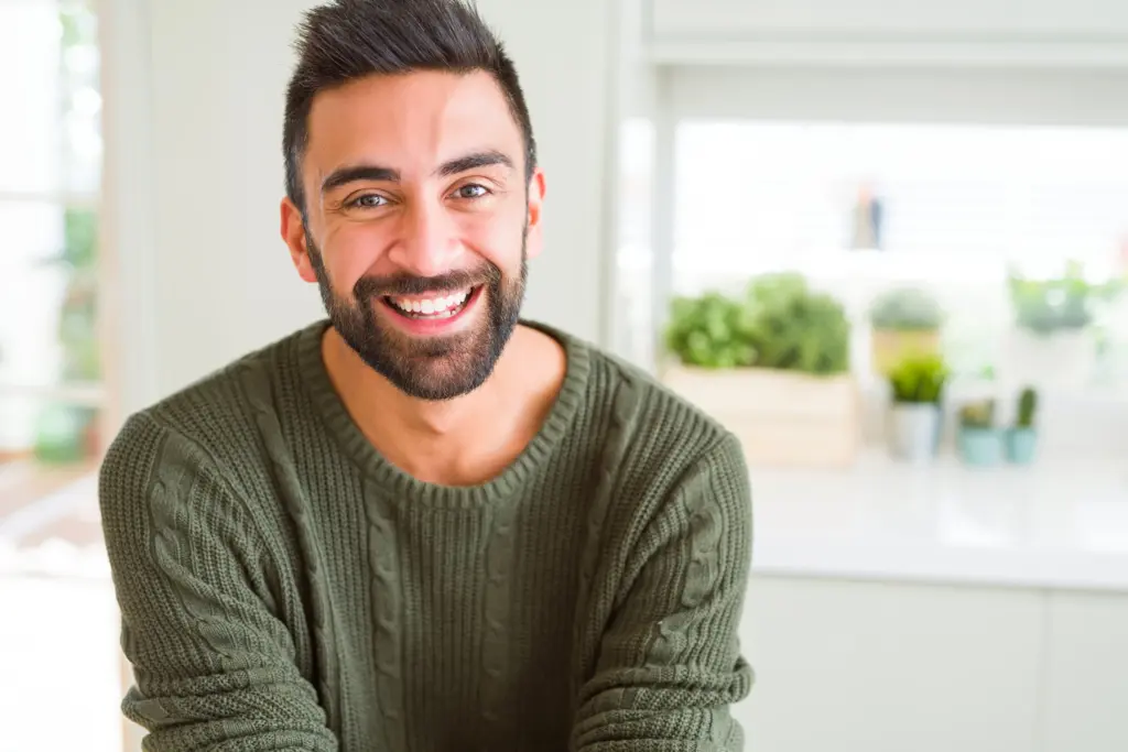 Smiling bearded man in a green sweater