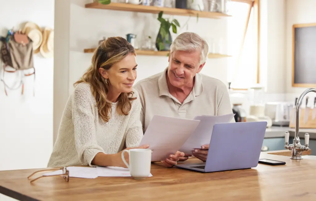 Couple reviewing bills together at a laptop