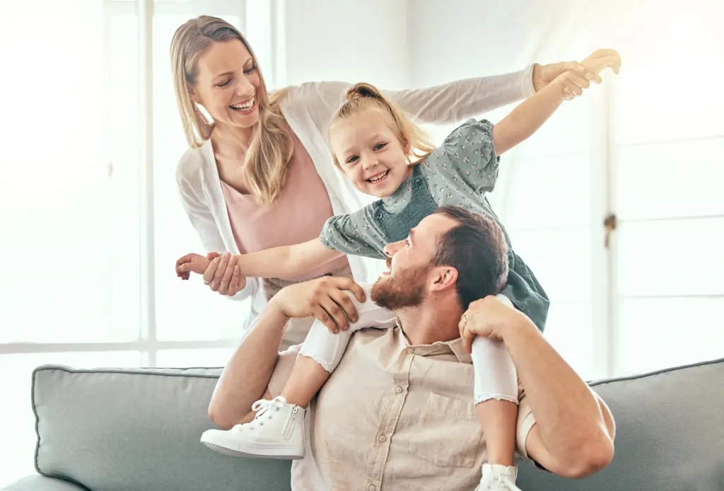 Parents playing with their young daughter at home