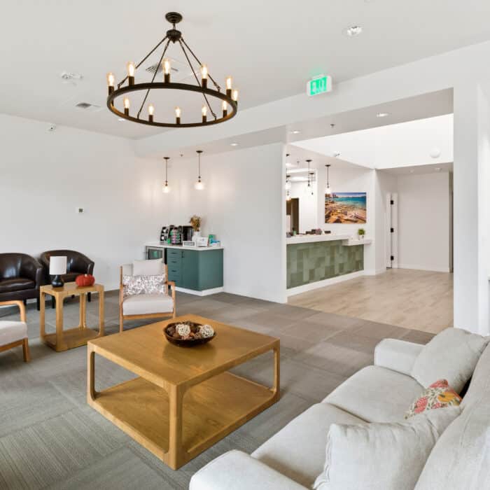 Waiting area with a chandelier, coffee table and sofas