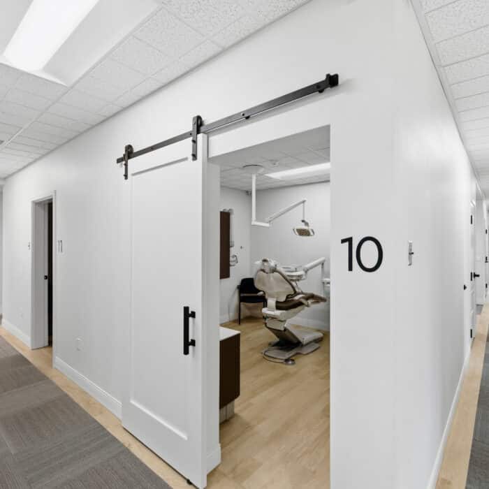 Hallway with a sliding barn door to treatment room 10