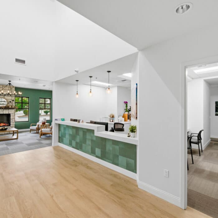 Reception desk with a green tiled front beside the waiting room