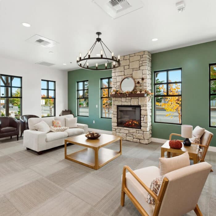 Waiting room with a stone fireplace, sofa and armchairs